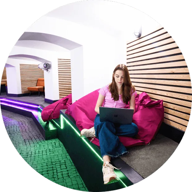 An FMG employee working on a laptop in a breakout space at the Brighton headquarters