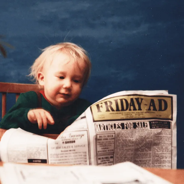 Sam Kidger as a young child reading a copy of the Friday-Ad