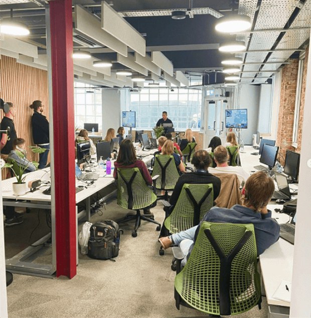 The FMG team gathered in the open-plan headquarters office for a company talk